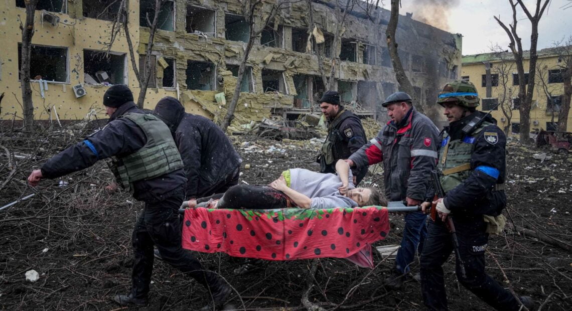 Ukrainian emergency employees and volunteers carry an injured pregnant woman from the damaged by shelling maternity hospital in Mariupol, Ukraine on March 9. (AP Photo/Evgeniy Maloletka)