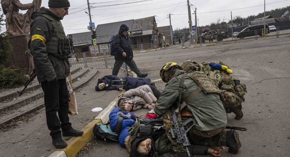 Ukrainian soldiers tried to save a man, the only one who still had a pulse, after being hit by a mortar while trying to flee Irpin, near Kyiv, Ukraine, on Sunday.LYNSEY ADDARIO/NYT